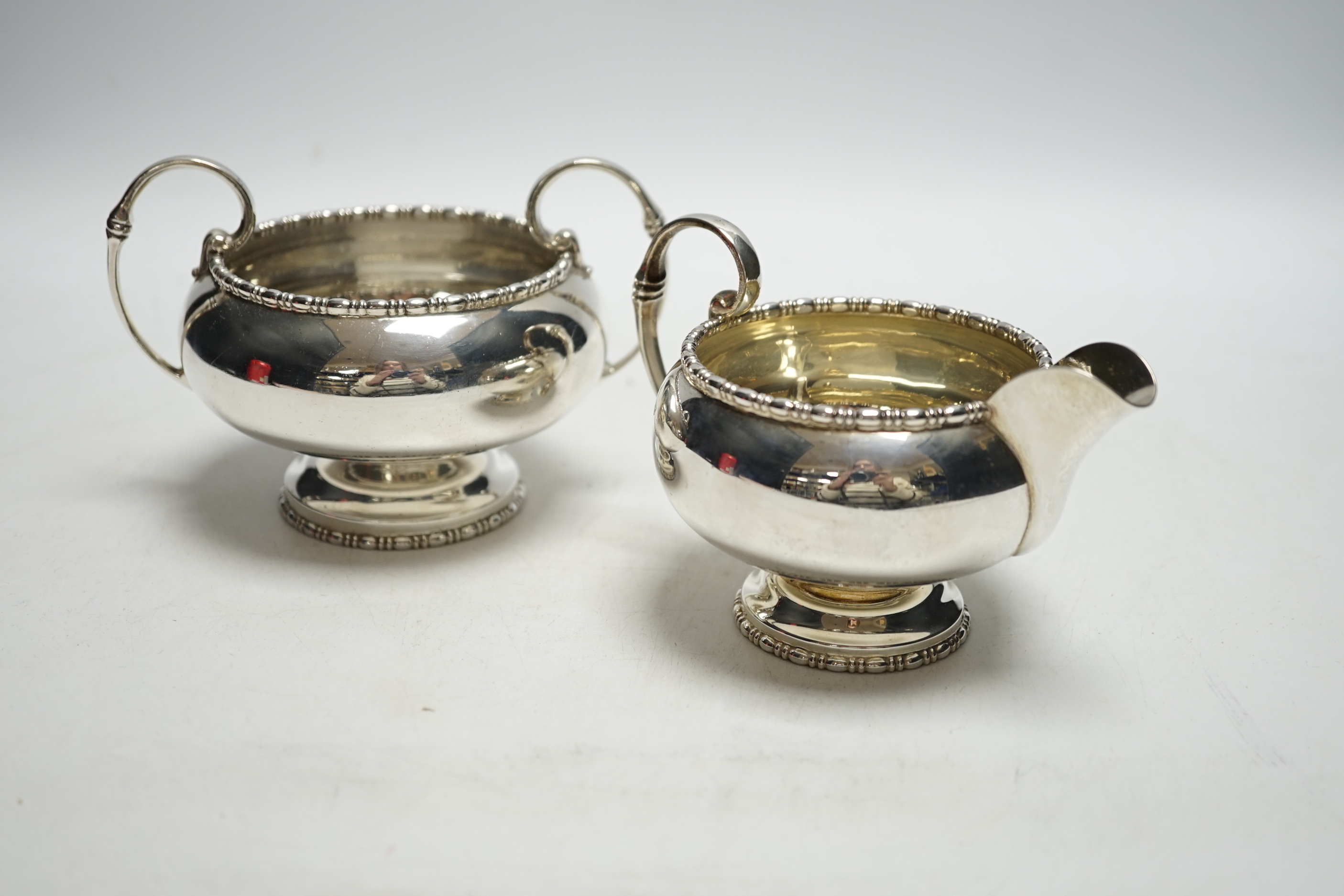 A George VI silver two handled sugar bowl and matching cream jug, Walker & Hall, Sheffield, 1950, 12.8oz.